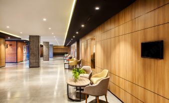 a modern hotel lobby with wooden walls , a reception desk , and several chairs arranged around it at Ibis Styles Bekasi Jatibening