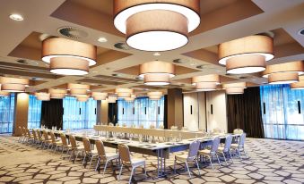 a large conference room with multiple rows of chairs arranged in a semicircle around a long table at Steigenberger Hotel Koln