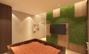 A living room with an attached bedroom and a flat-screen TV mounted on the wall above it at De Elements Business Hotel KL