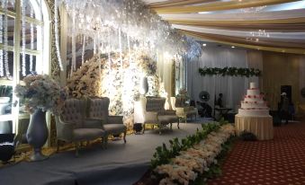 a large banquet hall decorated for a wedding , with chairs arranged in a row for guests at Grand Elty Singgasana Tenggarong