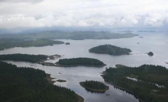 a vast expanse of water with islands and greenery , set against a cloudy sky background at Waterfall Resort