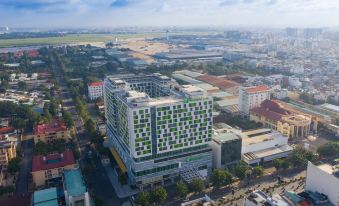 an aerial view shows the city and its surrounding buildings, including a large white building with no specific details provided at Holiday Inn & Suites Saigon Airport