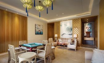 a modern living room with white furniture , blue and gold ceiling decorations , and a large screen tv at Sanya Xizang Hotel