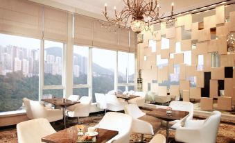 The modern room features large windows, chandeliers, and tables in the dining area at Regal Hongkong Hotel