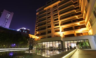 At night, the hotel building is surrounded by greenery and illuminated at Metropolo Dahua Hotel Shanghai