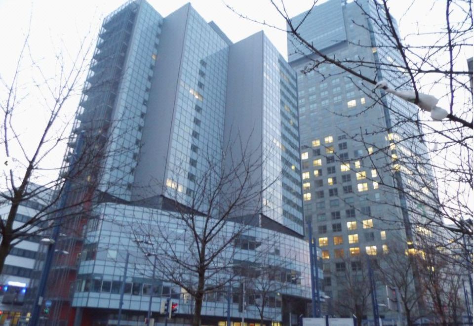 a city street with two tall buildings , one on the left side and the other on the right side of the street at Hotel Luna