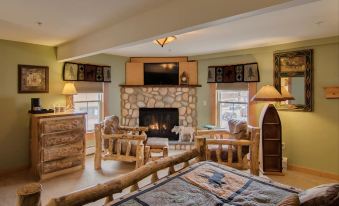 a cozy living room with a fireplace , a flat - screen tv , and a dining table in the corner at Woodstock Inn, Station and Brewery