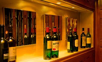 a wooden shelf with three wine bottles arranged on it , along with several wine glasses at Hotel-Restaurant Bären