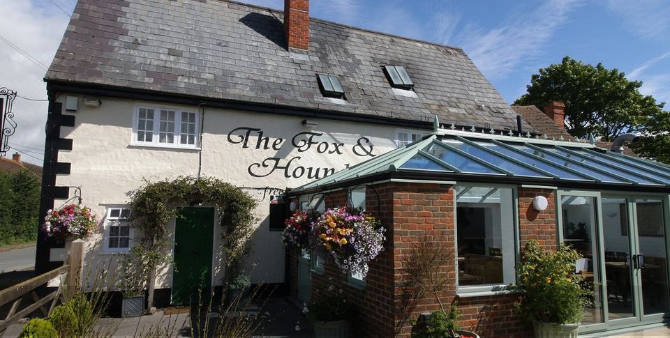 "a brick house with a sign that reads "" the fox & hound "" on the side of it" at The Fox & Hounds