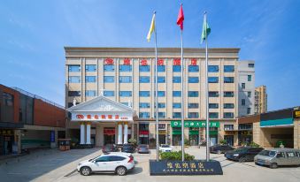 a large hotel building with multiple flags flying in front of it , creating a festive atmosphere at Vienna Hotel