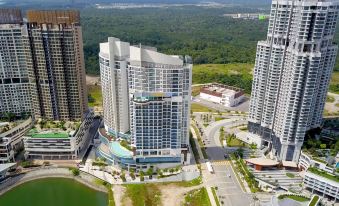 aerial view of a modern building surrounded by trees and water , with a pool in the foreground at Fraser Place Puteri Harbour, Johor