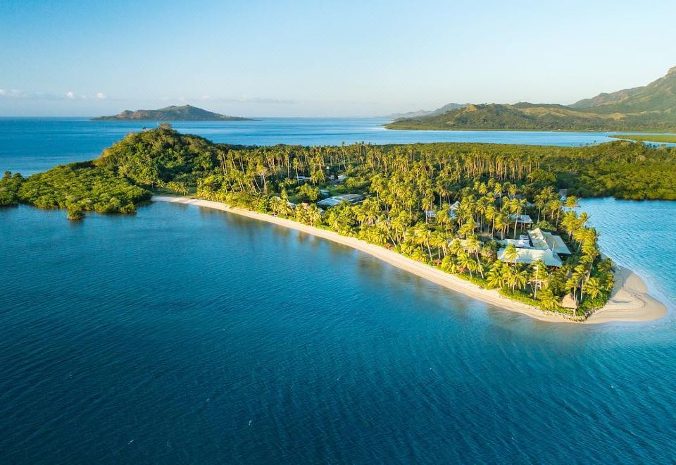 aerial view of a tropical island with a small island surrounded by palm trees and a beach at Nukubati Great Sea Reef