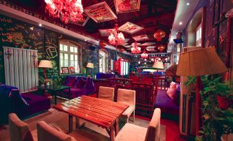 The restaurant features an Asian-themed dining area with tables, chairs, and ceiling lights at 7 Sages International Youth Hostel