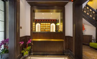 The hotel's front entrance features elegant wood paneling and leads to a welcoming entryway at Huaihai Mansion