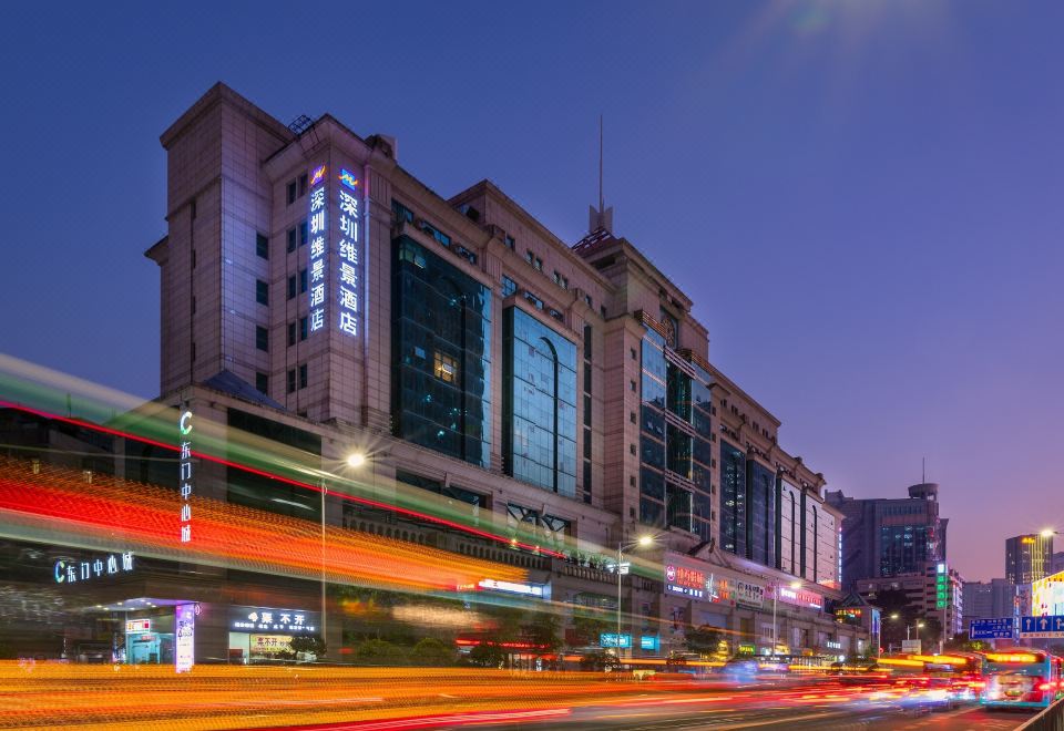 A cityscape at night with a building in the foreground and other buildings on both sides at Metropark Hotel Shenzhen