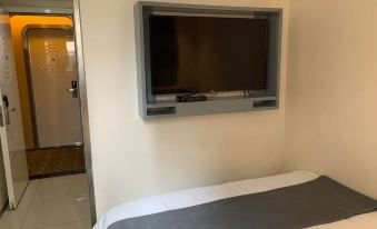 The bedroom features a large flat-screen TV mounted on the wall, with the bed positioned either in front or behind it at Zhotels (Shanghai West Nanjing Road Westgate Mall)