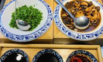 A tray with filled bowls and plates, including soup, is placed alongside other dishes at Motel Hotel (Shanghai Changping Road Metro Station)