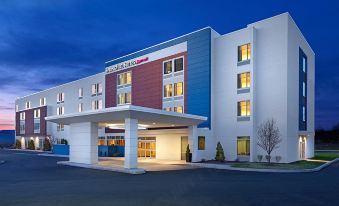 a large white building with a red and blue facade , featuring the exterior of the building lit up at night at SpringHill Suites Oklahoma City Downtown/Bricktown