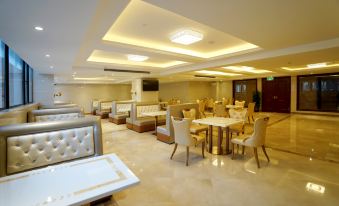 The restaurant features a central area with tables and chairs, as well as an open concept dining room at Vienna International Hotel (Shanghai Pudong Airport Free Trade Zone)