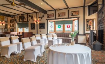a room with white chairs and tables set up for a formal event , possibly a wedding or conference at Mick O'Sheas