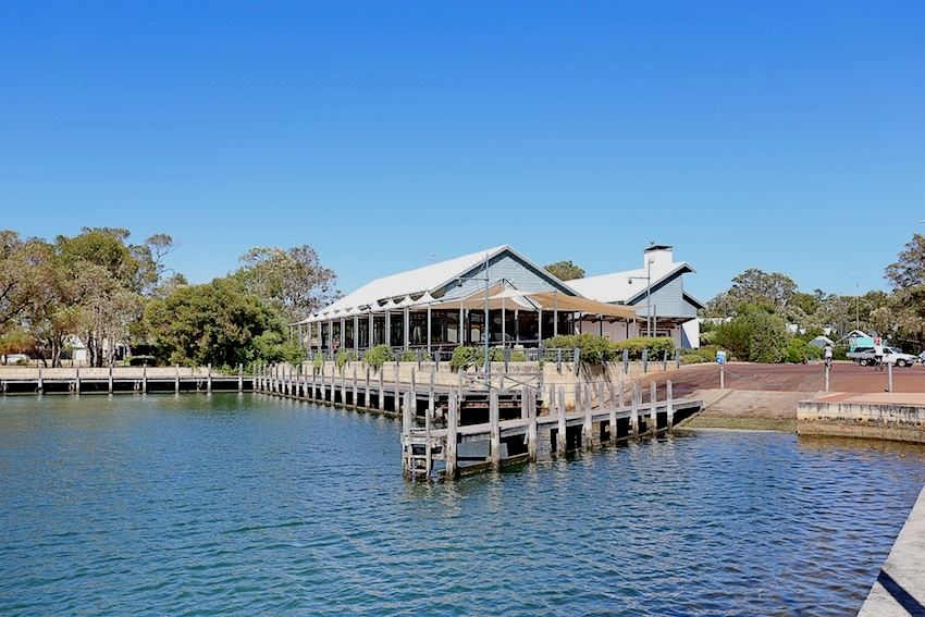 a large wooden pier extending into a body of water , with several people standing on it and enjoying the view at Mandurah Quay Resort