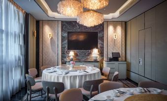 The room is illuminated and arranged with round tables and chairs for an event at The Emperor Hotel