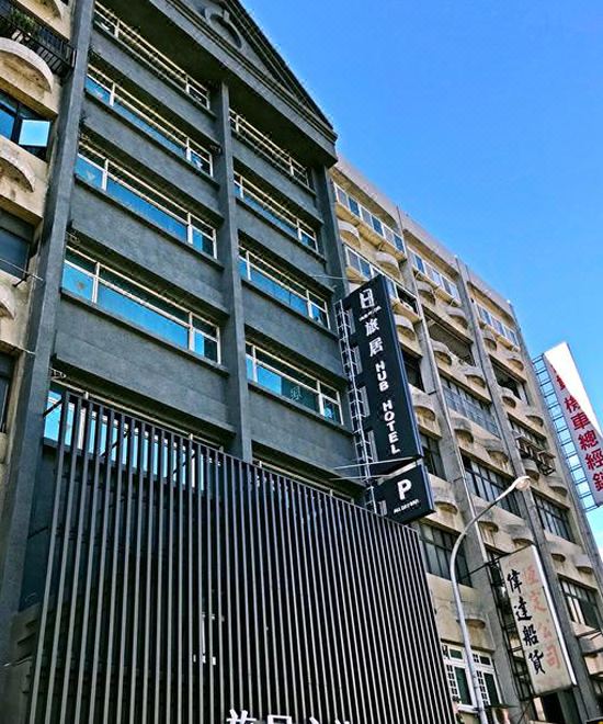 a modern building with a large sign on the side of it , indicating that it is an office building at Hub Hotel