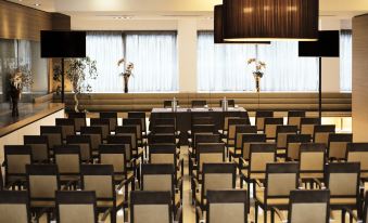 a conference room with rows of chairs arranged in a semicircle , and a podium at the front at Antony Palace Hotel - Venice Airport