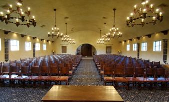 an empty auditorium with rows of wooden chairs and a long table at the front at Tubac Golf Resort & Spa