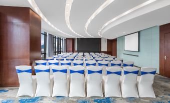 A spacious event room is arranged with blue and white chairs along the head table at Shenzhen Huaqiang Plaza hotel (Huaqiangbei Metro Station)