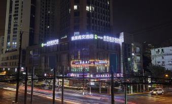 At night, a city is illuminated by buildings in blue and white colors at Meego Qingwen Hotel