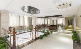 A large room with glass walls and floors features an atrium connecting to the second floor at Kaiserdom Hotel (Guangzhou Baiyun Airport)