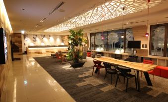 a modern hotel lobby with various seating options , including couches , chairs , and a dining table at Kichijoji Tokyu Rei Hotel