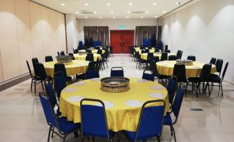 a large dining room with multiple round tables and chairs arranged for a group of people at Star Well Hotel