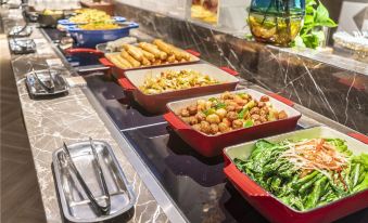 The fast food restaurant offers a diverse selection of buffet items on its serving table at Metropolo Jinjiang Hotel (Harbin Haxi High-speed Railway Station Wanda Plaza)