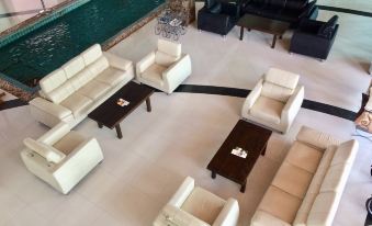 an aerial view of a large room with white couches and a pool in the background at Siam Triangle Hotel