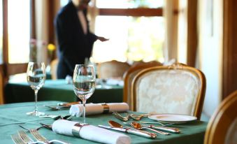 a dining room with a table set for a meal , featuring multiple wine glasses and silverware at Nara Hotel