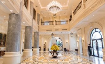 a large , elegant hotel lobby with white walls and a chandelier hanging from the ceiling at Wellington Hotel
