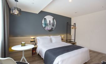 a spacious bedroom with a double bed and a large mirror positioned above the headboard at Jimu Xiaozhu Hotel (Shanghai Jing'an Temple)