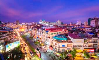 a bustling city street at night , with numerous cars and buildings lit up in the evening at Paradise Hotel