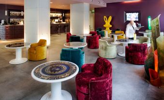 a modern living room with various seating options , including couches , chairs , and ottomans , arranged around a coffee table at Hotel Da Vinci