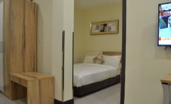 a clean and well - organized hotel room with a comfortable bed , a dresser , and a tv at My Inn Hotel Kota Samarahan