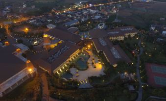 an aerial view of a large hotel complex at night , with multiple buildings and illuminated lights at The Singhasari Resort Batu