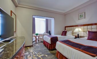 a hotel room with two beds , one on the left and one on the right side of the room at Hotel Lulu