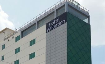 a hotel with a large sign on the side of the building , indicating the name of the hotel at Hotel Valentino