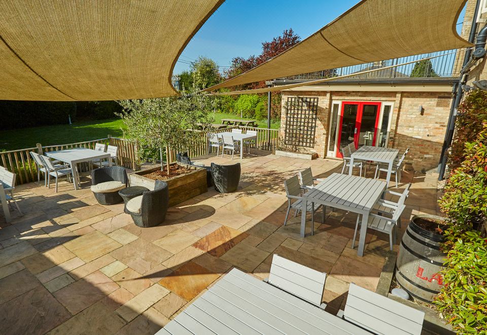 an outdoor dining area with tables , chairs , and umbrellas , providing a pleasant atmosphere for guests at The Cadogan Arms