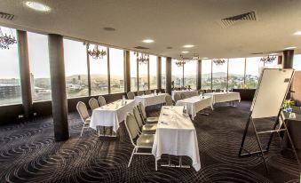 a large conference room with several long tables set up for a meeting or event at Mercure Brisbane Spring Hill