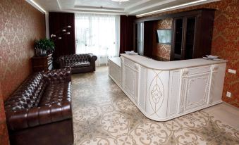 a luxurious hotel lobby with a marble floor , brown leather couches , and a large white reception desk at Vernisage