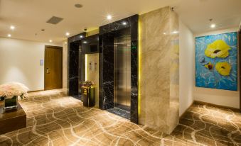 a modern elevator in a hotel lobby with marble walls and carpeted floor , under bright lights at DTX Hotel Nha Trang