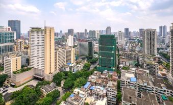 From a high vantage point, one can see a city characterized by tall buildings and large skyscrapers in its center at Guangzhou Feiyang Apartment